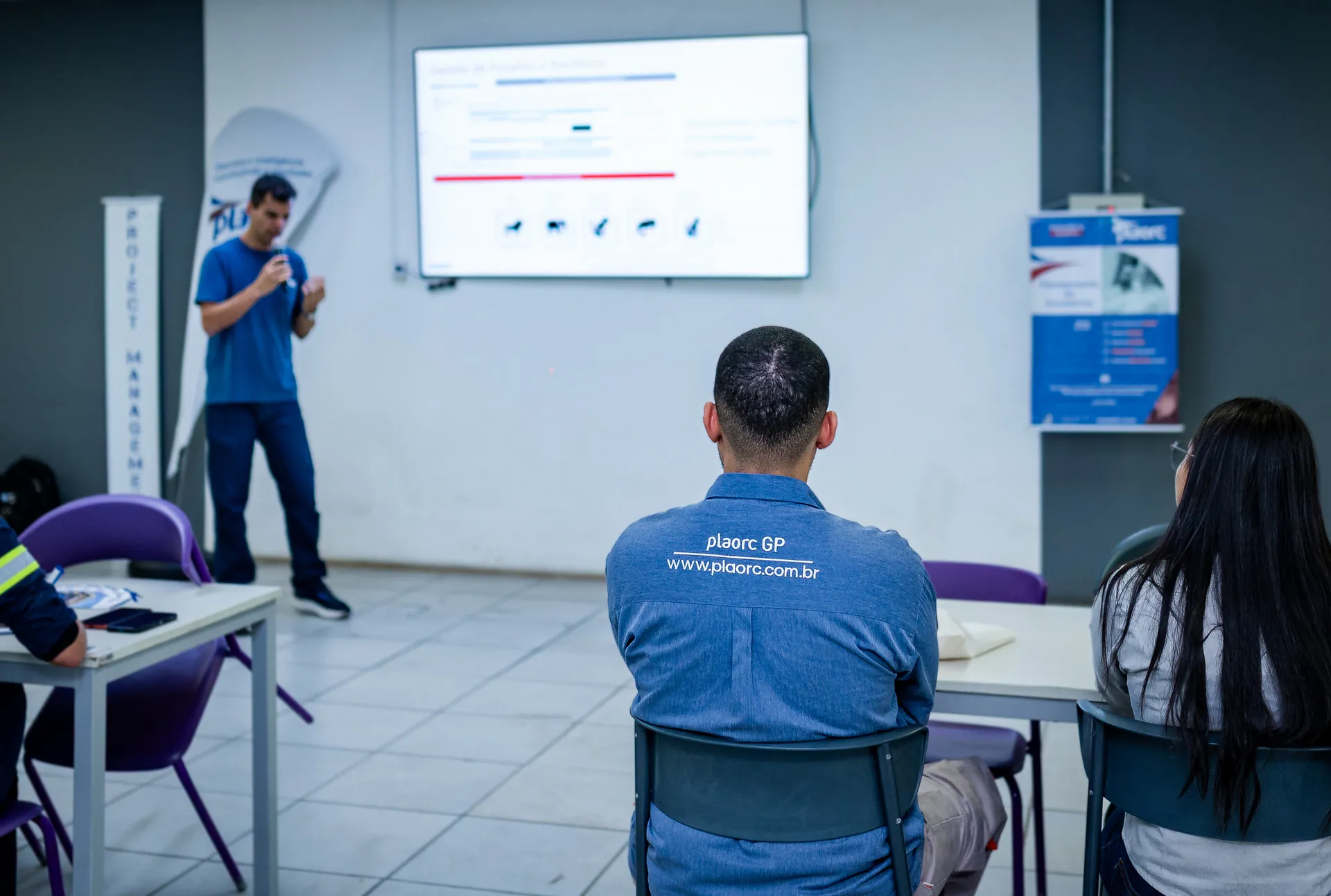 Instrutor da PLAORC conduzindo um treinamento sobre planejamento e gestão de projetos para uma turma